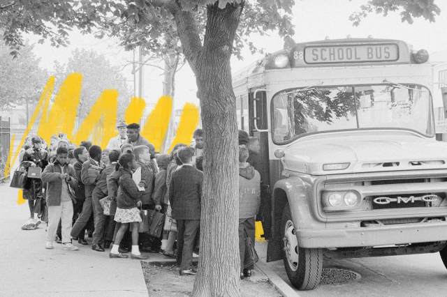 Children get on a school bus, 1960s